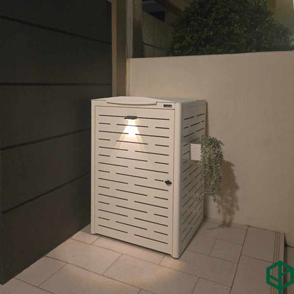 White outdoor trash bin with a textured design on a patio area.