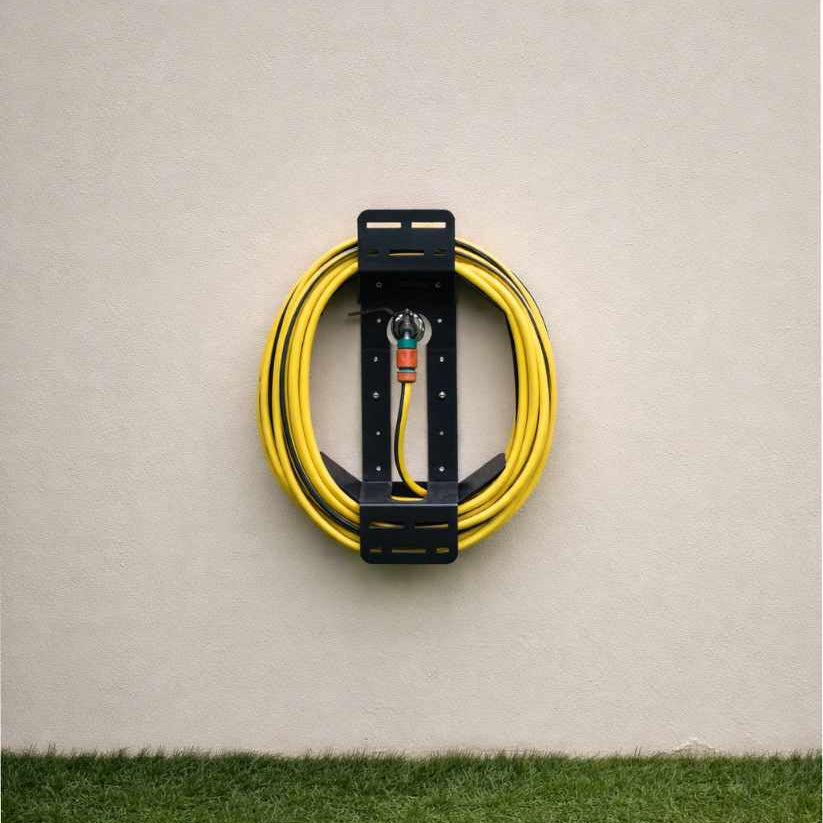 Coiled yellow cable with a black holder on a beige wall.